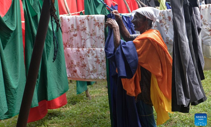 A worker hangs clothes to dry on a laundry line at a community named Laundrywatte in Colombo, Sri Lanka on Dec. 13, 2024. (Photo: Xinhua)