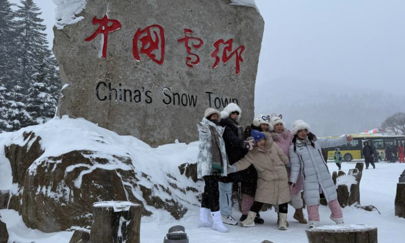 Tourists pose for photos near the sign of a snow town scenic area in Hailin City, northeast China's Heilongjiang Province, Dec. 28, 2024. Located in Hailin City of Heilongjiang Province, the scenic area has seen a peak of tourism recently with the average number of daily visitors exceeding 20,000. (Xinhua/Yang Siqi)