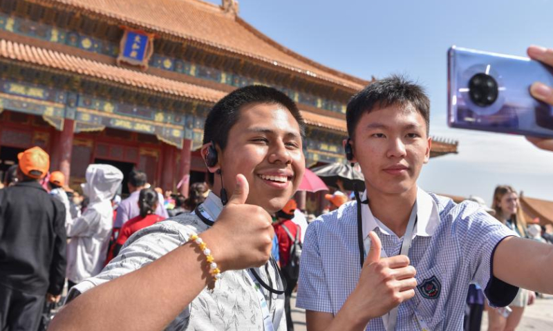 A student (L) of the Muscatine High School delegation takes selfies at the Palace Museum in Beijing, capital of China, April 18, 2024. (Photo by Liu Zunshuan/Xinhua)