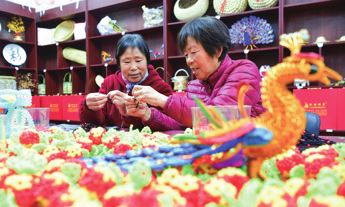 Two workers make accessories by hand in Xinji, North China's Hebei Province on December 26, 2024. The city has supported the development of handicrafts, processing various accessories such as weaving, clothing, hats and shoes, providing jobs for over 10,000 people. The handmade products have been exported to the UK, South Korea and other countries and regions. Photo: VCG