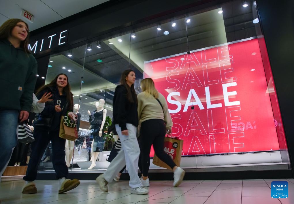 People walk past a store during the Boxing Day sale in Vancouver, British Columbia, Canada, on Dec. 26, 2024. (Photo by Liang Sen/Xinhua)