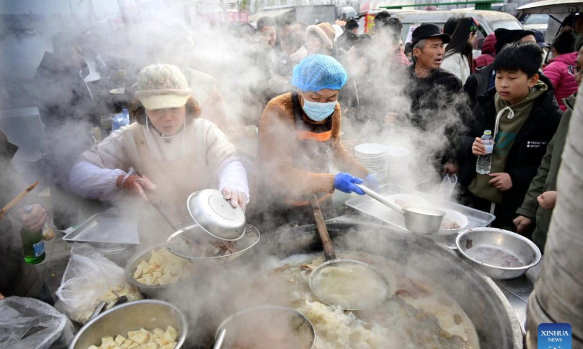 People buy local delicacy at the Poli Market in Qingdao Xihai'an (West Coast) New Area in Qingdao, east China's Shandong Province, Jan. 18, 2025. With a history of more than 300 years, the Poli Market is a local intangible cultural heritage and one of the biggest traditional markets in eastern Shandong Province. As the Spring Festival approaches, many visitors flock to the market for abundant new year decorations, agricultural products, local delicacies and so on. (Xinhua/Li Ziheng)