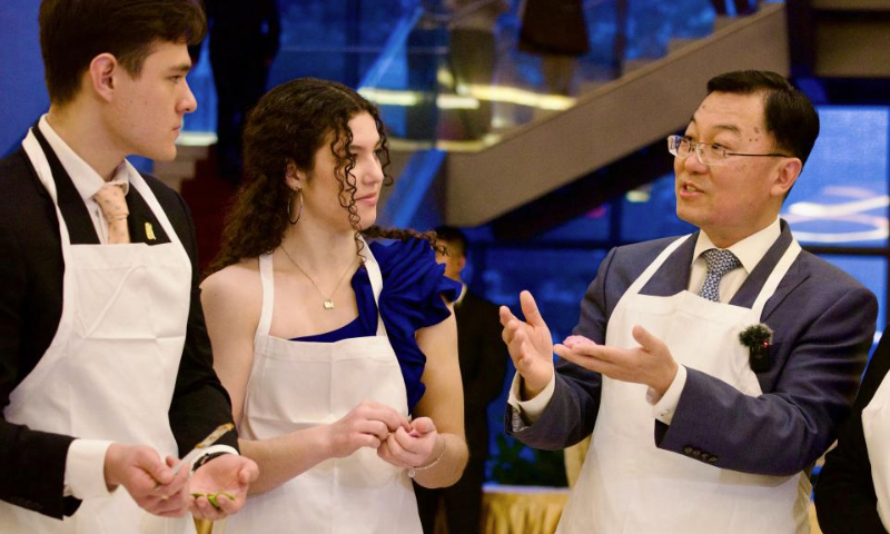 Chinese Ambassador to the United States Xie Feng (R) makes dumplings with American youths during the 2025 Spring Festival Gala for Chinese and American Youths at the Chinese Embassy in Washington, D.C., the United States, Jan. 11, 2025. The Chinese Embassy in the United States recently hosted the 2025 Spring Festival Gala for Chinese and American Youths, with over 500 young students from both countries and members of the American education community in attendance. (Xinhua/Deng Xianlai)