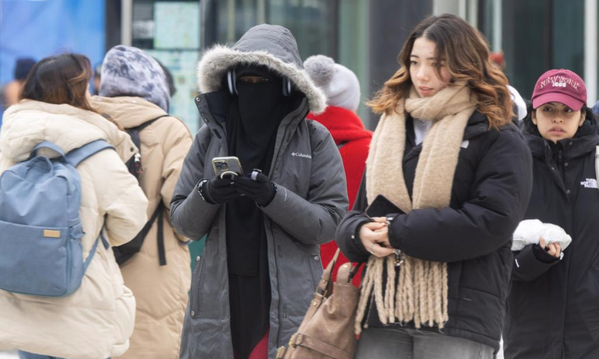 People brave the cold as they walk on a street in Toronto, Canada, on Jan. 21, 2025. Environment Canada issued an extreme cold warning for the City of Toronto on Tuesday, with wind chill values near minus 30 degrees Celsius to as low as minus 35 degrees Celsius. (Photo by Zou Zheng/Xinhua)
