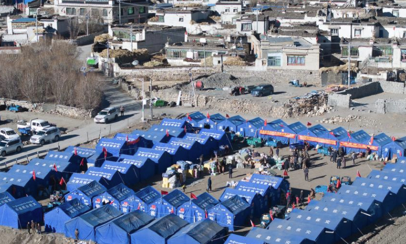 An aerial drone photo taken on Jan. 11, 2025 shows a temporary resettlement site in Pucun Village of Sagya County in Xigaze City, southwest China's Xizang Autonomous Region. Water, food, fuel and other disaster relief materials have been delivered to the temporary resettlement site for the earthquake-affected residents of Pucun Village in Sagya County. Construction of prefabricated houses also began on Saturday afternoon. (Xinhua/Li Xiang)