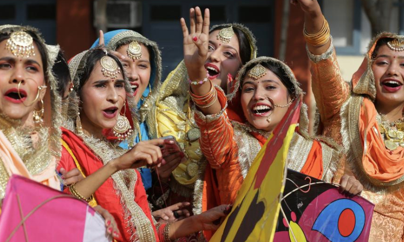 Indian college students wearing traditional Punjabi attire celebrate the Lohri festival in Amritsar district of India's northern Punjab state, Jan. 13, 2025. The Lohri festival event is celebrated annually on Jan. 13 by flying kites and lighting bonfires. (Str/Xinhua)