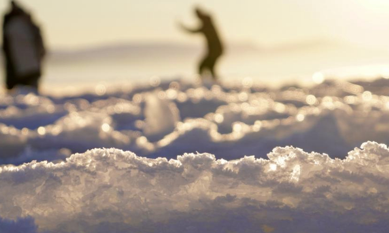 Tourists take photos on the frozen surface of Sayram Lake at sunset in Bortala Mongolian Autonomous Prefecture, northwest China's Xinjiang Uygur Autonomous Region, Jan. 13, 2025. Sayram Lake is the largest and highest alpine lake in Xinjiang. (Xinhua/Du Juanjuan)