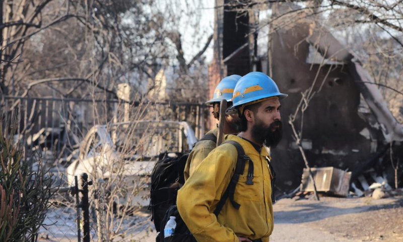 Firefighters work in the wildfire-ravaged area of Altadena, Los Angeles County, California, the United States, on Jan. 10, 2025. Devastating wildfires continue to rage across different parts of Los Angeles County on Friday, leading to widespread disruptions, including school closures and the cancellation of entertainment, sports, and community events.

As of Friday, the wildfires have destroyed more than 12,300 structures and claimed at least 11 lives, with officials warning the true death toll will remain unclear until it is safe for investigators to go into neighborhoods. More than 100,000 people are under evacuation orders, with tens of thousands more under warnings. (Photo by Qiu Chen/Xinhua)
