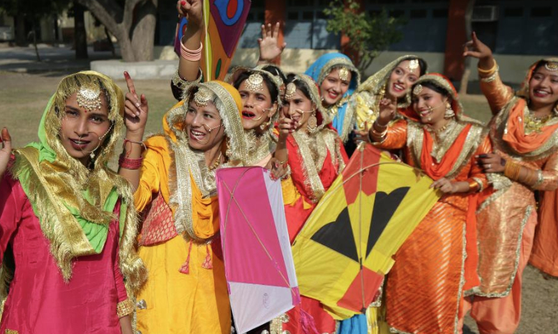 Indian college students wearing traditional Punjabi attire celebrate the Lohri festival in Amritsar district of India's northern Punjab state, Jan. 13, 2025. The Lohri festival event is celebrated annually on Jan. 13 by flying kites and lighting bonfires. (Str/Xinhua)