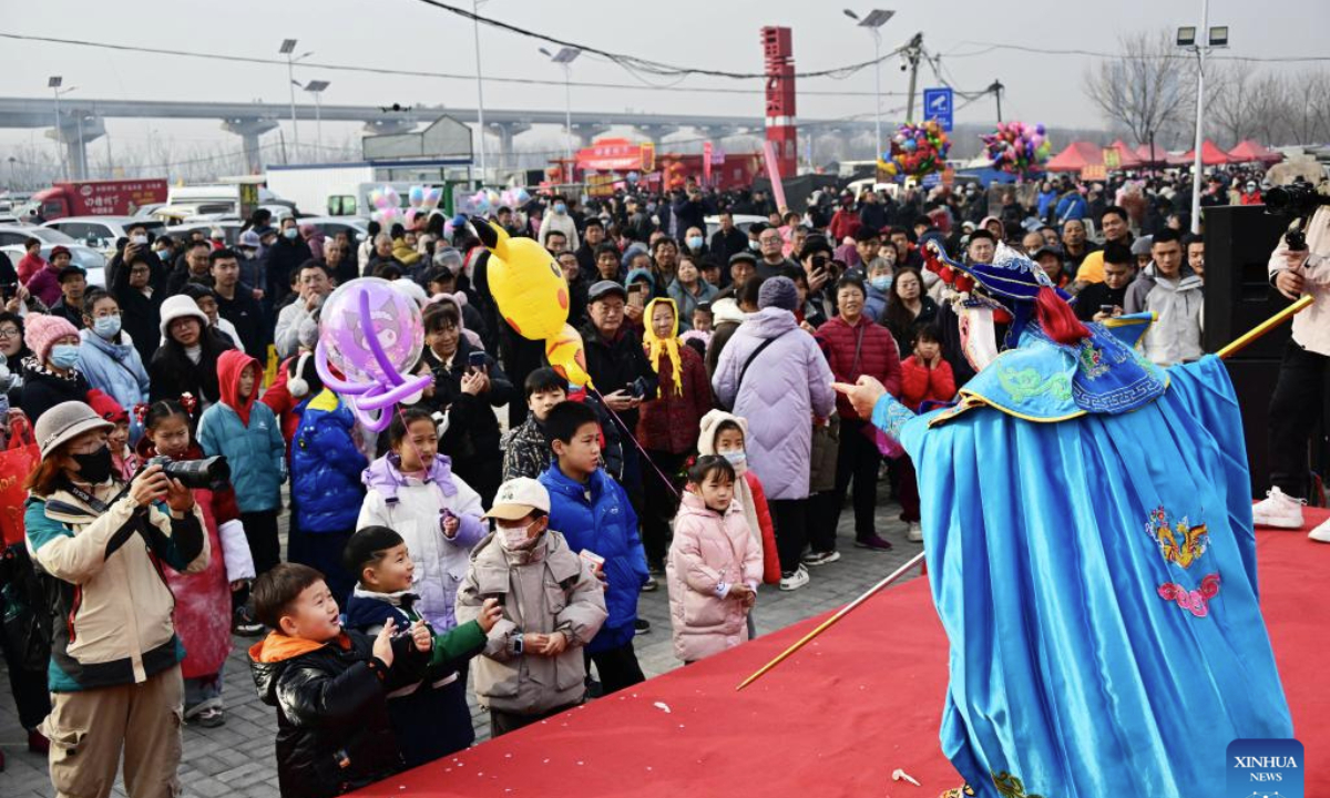 People watch an opera performance at the Poli Market in Qingdao Xihai'an (West Coast) New Area in Qingdao, east China's Shandong Province, Jan. 18, 2025. With a history of more than 300 years, the Poli Market is a local intangible cultural heritage and one of the biggest traditional markets in eastern Shandong Province. As the Spring Festival approaches, many visitors flock to the market for abundant new year decorations, agricultural products, local delicacies and so on. (Xinhua/Li Ziheng)