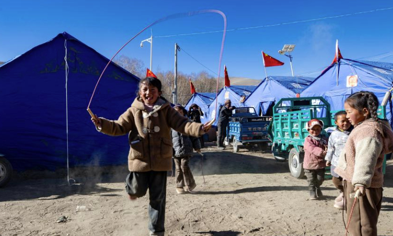 Children play at a temporary resettlement site in Pucun Village of Sagya County in Xigaze City, southwest China's Xizang Autonomous Region, Jan. 11, 2025. Water, food, fuel and other disaster relief materials have been delivered to the temporary resettlement site for the earthquake-affected residents of Pucun Village in Sagya County. Construction of prefabricated houses also began on Saturday afternoon. (Xinhua/Jiang Fan)