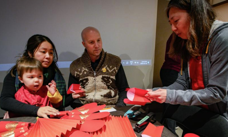 People learn to make Chinese New Year decorations using red packets at a craft workshop in Vancouver, British Columbia, Canada, Jan. 18, 2025. Celebrations and cultural activities are being held around the globe to welcome the upcoming Chinese New Year. (Photo by Liang Sen/Xinhua)