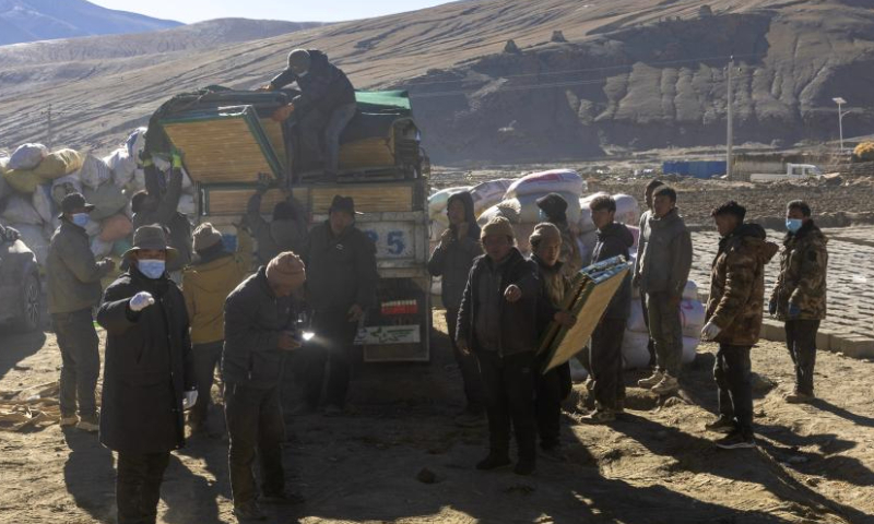 Earthquake-affected residents transfer disaster relief materials at a temporary resettlement site in Pucun Village of Sagya County in Xigaze City, southwest China's Xizang Autonomous Region, Jan. 11, 2025. Water, food, fuel and other disaster relief materials have been delivered to the temporary resettlement site for the earthquake-affected residents of Pucun Village in Sagya County. Construction of prefabricated houses also began on Saturday afternoon. (Xinhua/Bai Mingshan)