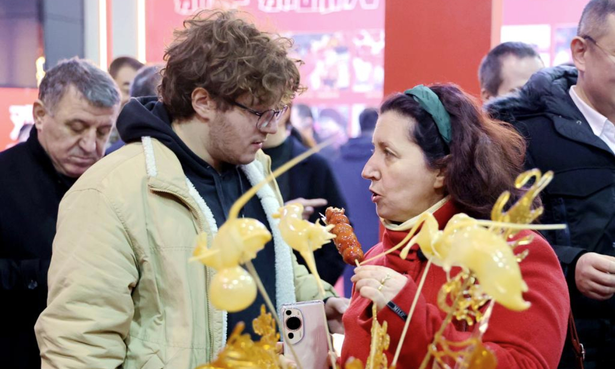 A member of the diplomatic corps tastes sugarcoated haws at a festive event for the upcoming Chinese New Year, or the Spring Festival, in Langfang, north China's Hebei Province, Jan. 23, 2025. (Xinhua/Wang Xiao)
