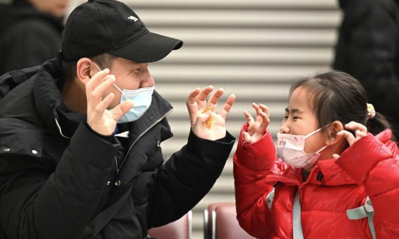 A father plays a game with his daughter at Zhengzhou East Railway Station in Zhengzhou, central China's Henan Province, Jan. 14, 2025. The Spring Festival, China's biggest traditional holiday, will fall on Jan. 29 this year. The Spring Festival travel rush, or chunyun, the world's largest annual human migration known for its high transportation demand as millions return home for family reunions, kicked off on Tuesday. (Xinhua/Li Jianan)