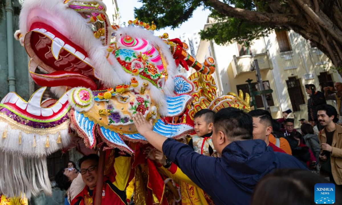 The dragon dance performing team interact with citizens during a tour event in celebration of the Chinese New Year at the St. Lawrence Parish in Macao, south China, Jan 29, 2025. Photo:Xinhua