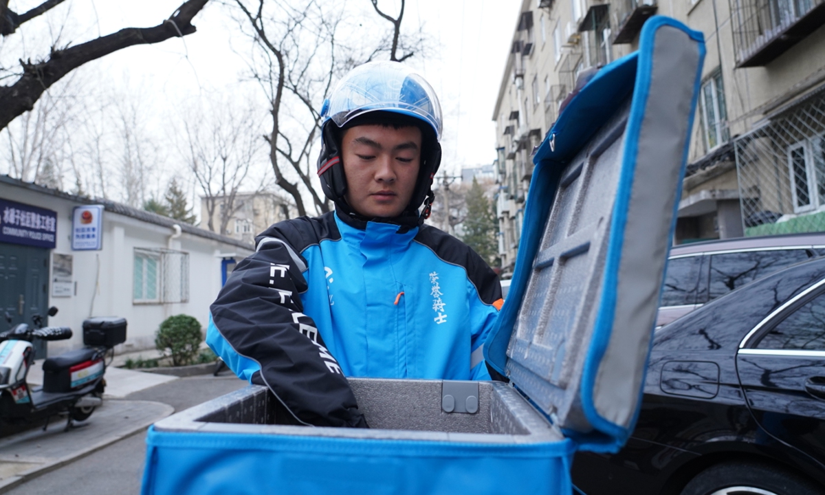 Food delivery rider Ma Zhipeng takes out a customer's food from the delivery box.  Photoe: Courtesy of Han Weizheng