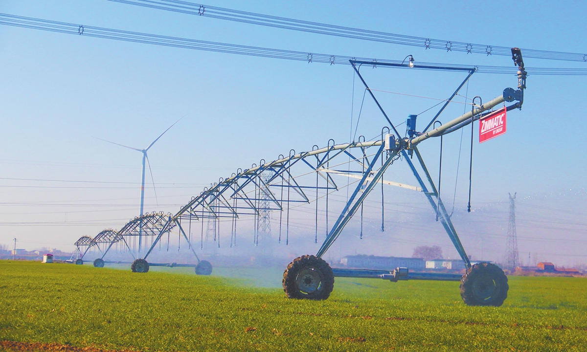 A piece of equipment integrating watering and fertilizing irrigates winter wheat in a field of Xinye county in Central China's Henan Province on January 16, 2025. With the support of smart technology, the county's farms have achieved significant water-saving benefits, with a water-saving rate of 48 percent. Photo: VCG