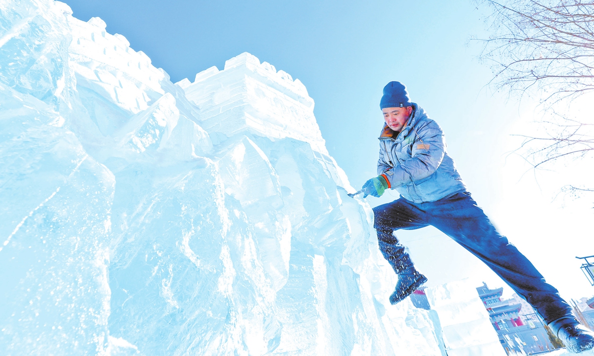 An ice sculptor recreates the Great Wall ice sculpture in Zhangye city, Northwest China's Gansu Province on January 15, 2025. As the Spring Festival holidays approach, localities ramp up efforts to launch activities including ice sculpture exhibitions to boost holiday spending. Photo: VCG
