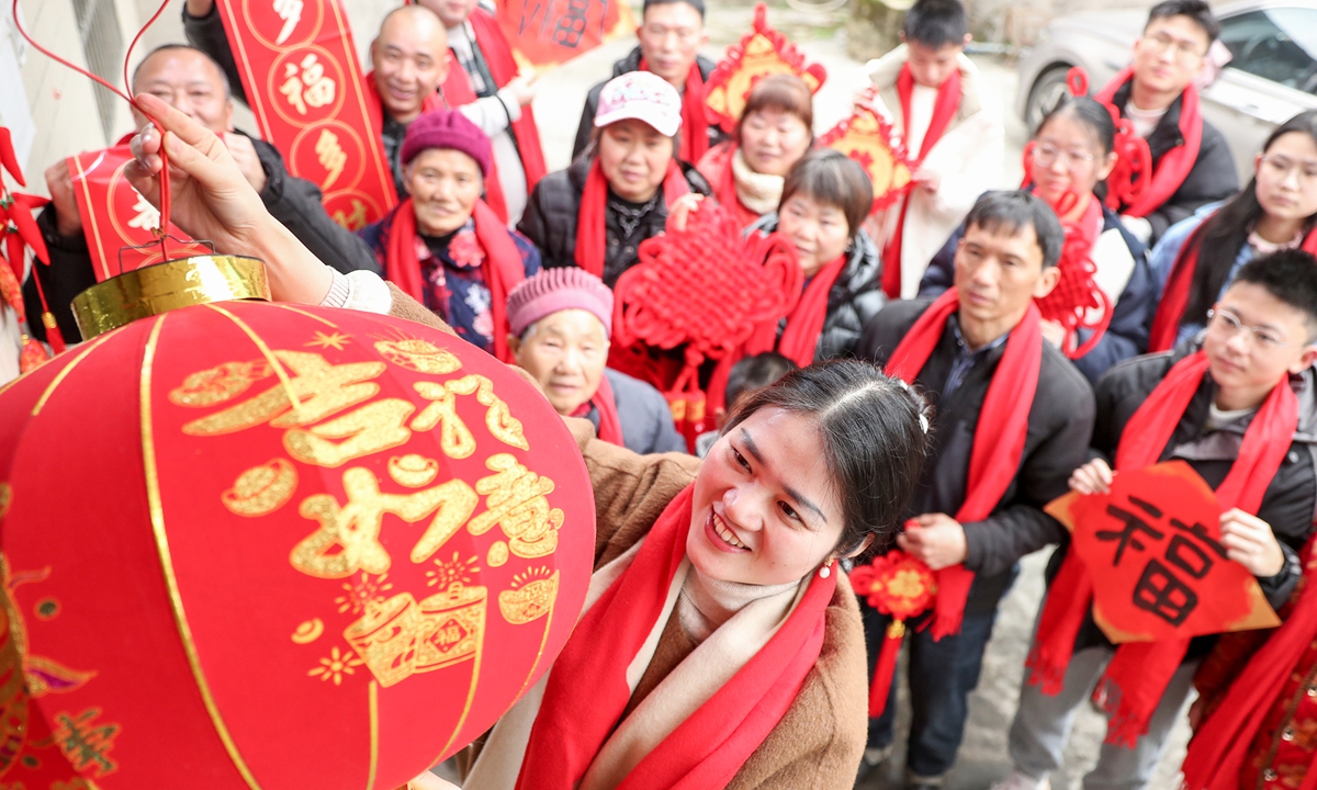 A family hangs up a red lantern on the door in a village of Huaying county, Guang'an, Southwest China's Sichuan Province on January 23, 2025, to welcome the Spring Festival. Photo: VCG