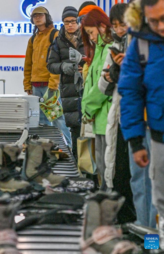 Tourists wait to pick up luggages at an airport in Altay, northwest China's Xinjiang Uygur Autonomous Region, Jan. 25, 2025. (Xinhua/Chen Shuo)