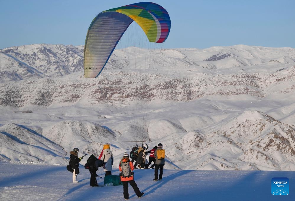 Tourists experience paragliding at Jiangjunshan Ski Resort in Altay, northwest China's Xinjiang Uygur Autonomous Region, Jan. 24, 2025. (Xinhua/Hu Huhu)

