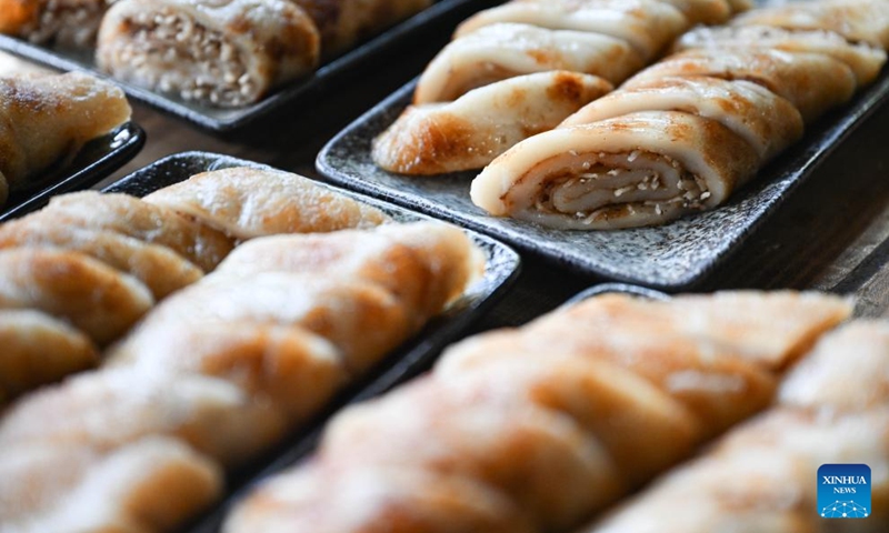 This photo taken on Jan. 28, 2025 shows rolls made from sticky rice and coconuts at Binglanggu tourism area in Baoting Li and Miao Autonomous County, south China's Hainan Province. An event featuring Li ethnic group culture was held at Binglanggu tourism area to celebrate the Chinese New Year, where tourists could dress in traditional Li attire and taste food with Li characteristics. Photo: Xinhua