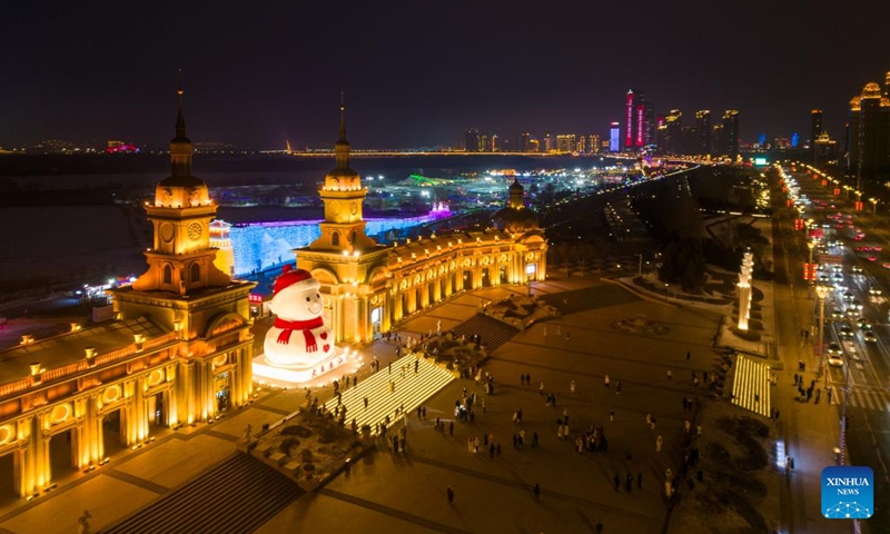 This aerial drone photo taken on Jan. 15, 2025 shows people having fun around a giant snowman by the Songhua River in Harbin, northeast China's Heilongjiang Province. As the 9th Asian Winter Games (AWG) approaching, Harbin, known for its stunning ice sculptures and deep-rooted winter sports culture, is brimming with anticipation. As the city's iconic landmark, the Harbin Ice-Snow World, with this year's edition, the largest in its history, boasts 1 million square meters. The park shares its theme this year with the upcoming AWG to be held in Harbin: Dream of Winter, Love Among Asia. Harbin, which successfully hosted the 3rd AWG in 1996, is once again stepping onto the world stage. The whole city is under an upgrade to provide better services for winter sports lovers and tourists. Photo: Xinhua