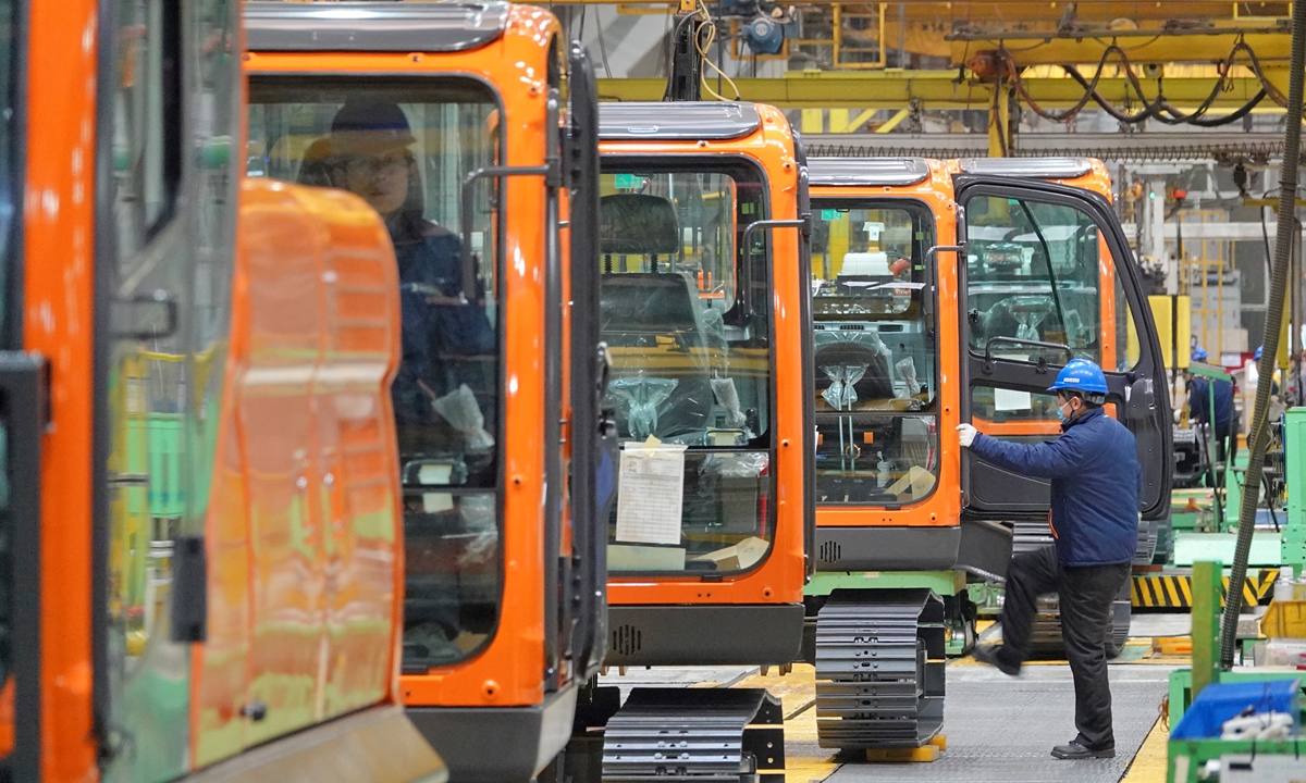 Workers are busy assembling excavators on the production line at a construction machinery manufacturing facility in an economic development zone of Yantai, East China's Shandong Province, on February 5, 2025. These machines are being prepared for shipment to domestic and international customers. Photo: VCG