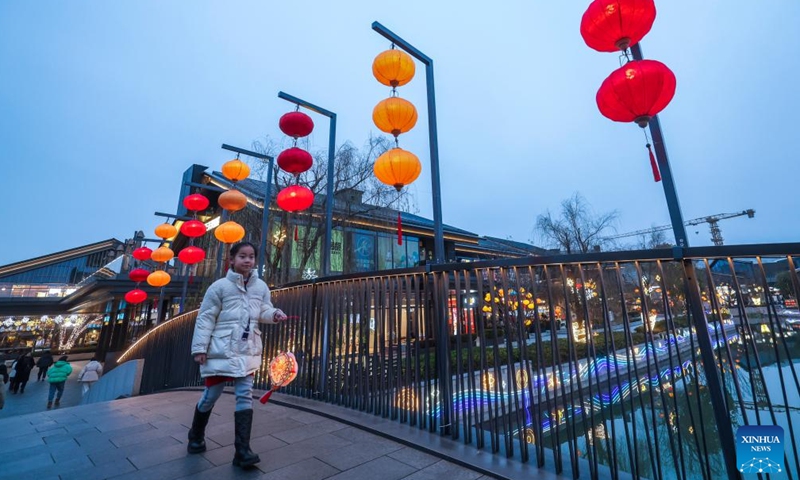 A girl holding a lantern walks on a bridge in Nanhu District of Jiaxing, east China's Zhejiang Province, Feb. 6, 2025. Festive preparations are underway in Nanhu District of Jiaxing for the upcoming Lantern Festival. (Xinhua/Xu Yu)