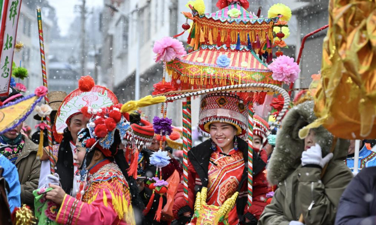 Folk artists of Lichuan Dengge parade on the street in Baiyangba Town, Lichuan City, Enshi Tujia and Miao Autonomous Prefecture, central China's Hubei Province, Feb. 6, 2025. Lichuan Dengge, originated from Lichuan City of Hubei Province, is a vibrant traditional folk art performed during festivals with colorful props like dragon boats and lantern carts. It features lively songs and interactive performances, reflecting the rich cultural heritage of the Tujia ethnic group. In 2011, Lichuan Dengge was listed among the third batch of national intangible cultural heritage. (Xinhua/Du Zixuan)