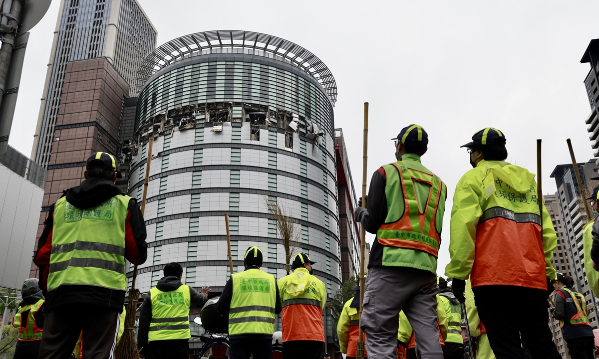 Workers look toward a damaged department store following a suspected gas explosion in Taichung, China's Taiwan island, on February 13, 2025. As of 4 pm, the casualty toll from the explosion was four deaths and 26 injured with varying degrees of severity, CCTV reported. Photo: VCG