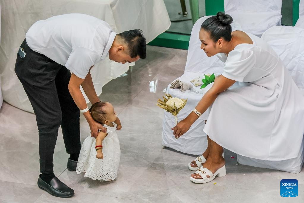 A couple plays with their daughter during a mass wedding ceremony on the eve of Valentine's Day in Quezon City, the Philippines, Feb. 13, 2025. A total of 280 couples tied the knot in the annual event organized by the local government. (Photo: Xinhua)