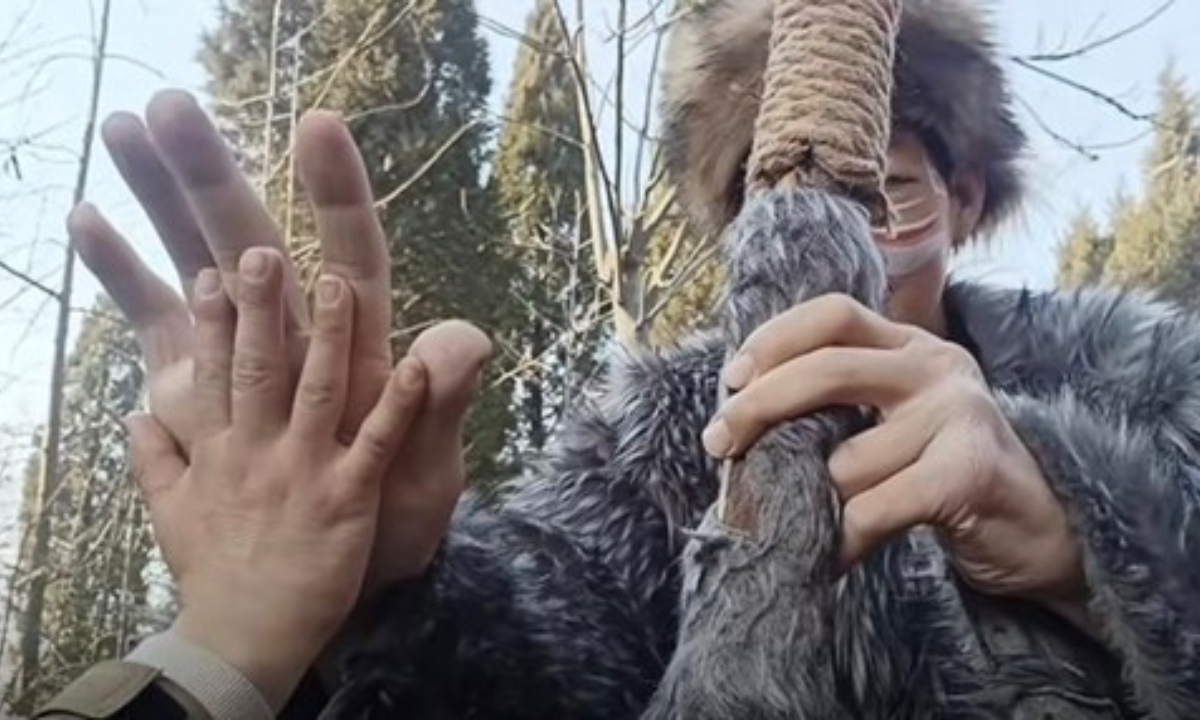 Visitor compares hand sizes with the giant actor at the scenic area. Photo: Screenshot of Daxiang News