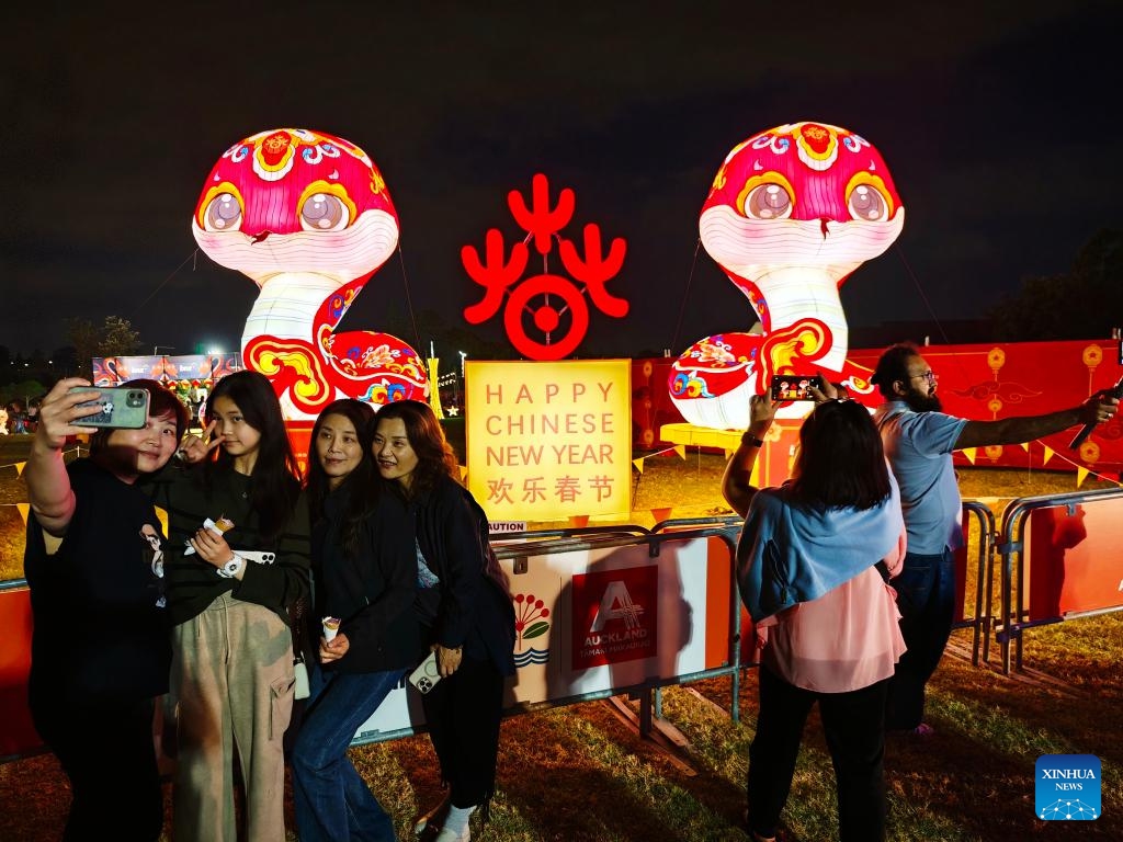 People pose for photos in front of snake-shaped lanterns during a Lantern Festival celebration in Auckland, New Zealand, on Feb. 13, 2025. (Photo: Xinhua)