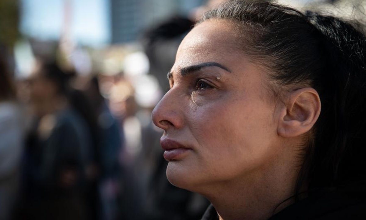 A woman watches the televised broadcast of the hostage release process through a big screen at a square in Tel Aviv, Israel, on Feb. 15, 2025. (Xinhua/Chen Junqing)