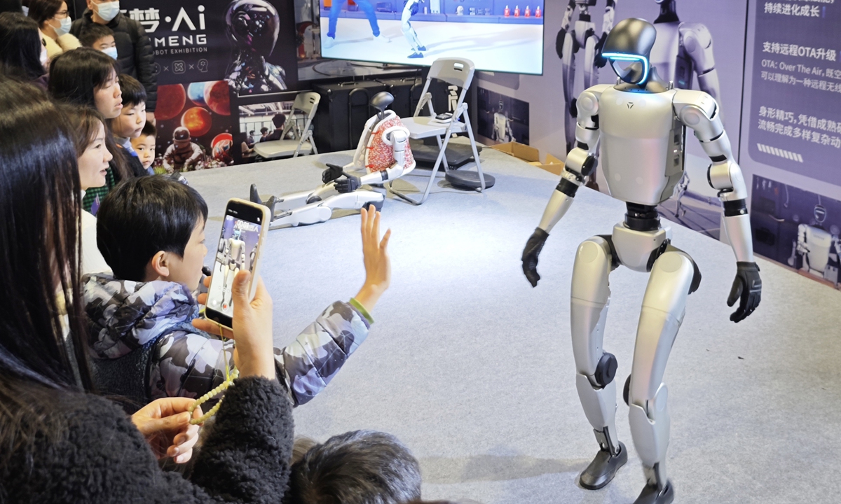 Visitors interact with humanoid robots at an AI intelligent robot exhibition in Nanjing, East China's Jiangsu Province, on February 16, 2025. An industry report projected that by 2029, China's market for humanoid robots is expected to reach 75 billion yuan ($10.34 million), accounting for 32.7 percent of the global market. Photo: VCG