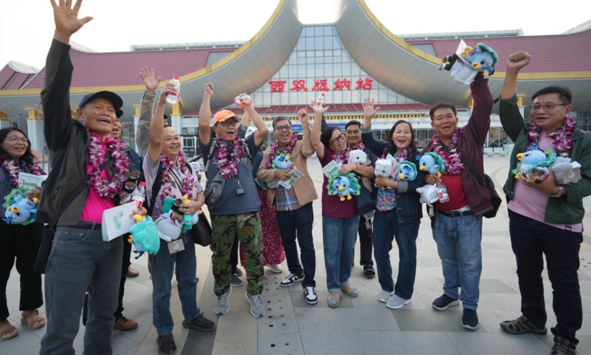 Tourists from a tour group, the first one from the Association of Southeast Asian Nations (ASEAN) member states since China introduced its new visa relaxation policy, pose for photos in front of the Xishuangbanna railway station in Jinghong City, Xishuangbanna Dai Autonomous Prefecture, southwest China's Yunnan Province, Feb. 18, 2025. (Xinhua/Chen Xinbo)