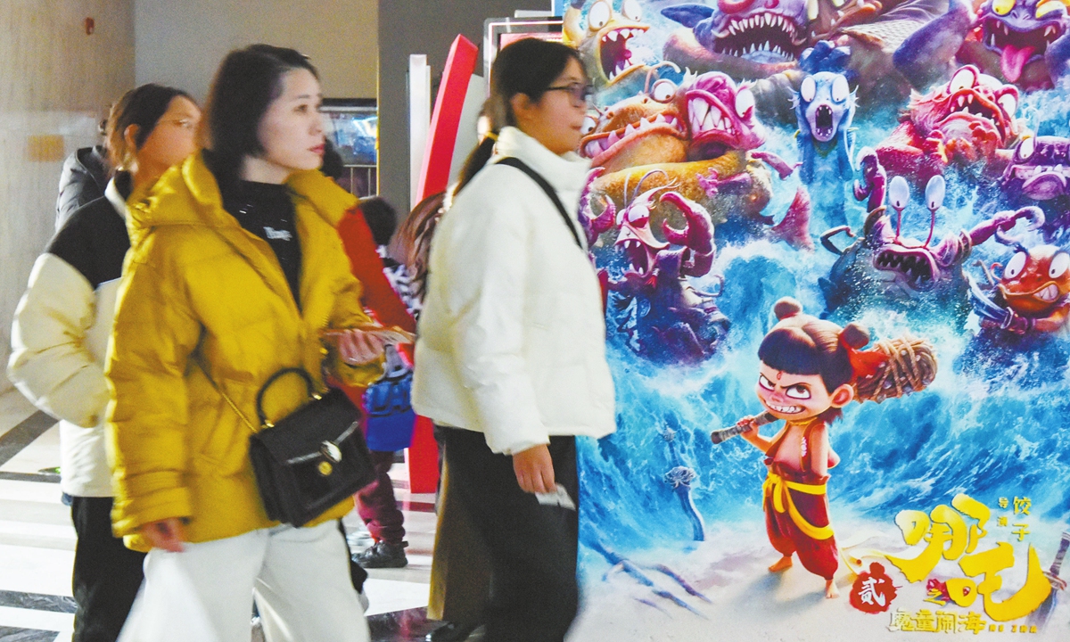 Moviegoers pass by a poster for Ne Zha 2 at a cinema in Fuyang, East China's Anhui Province, on February 16, 2025.