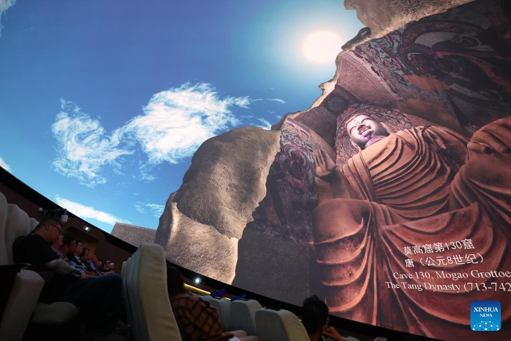 Tourists watch a fulldome digital movie in Dunhuang, northwest China's Gansu Province, Sept. 4, 2024. Around 2,000 years ago, Dunhuang was a key hub on the ancient Silk Road. Chinese silk and tea passed through this gateway en route to other countries, while agricultural products such as grapes, carrots and pomegranates made their way into China. Known for its breathtaking landscapes and historical significance, Dunhuang holds a treasure trove of ancient Buddhist relics and art. (Photo: Xinhua)