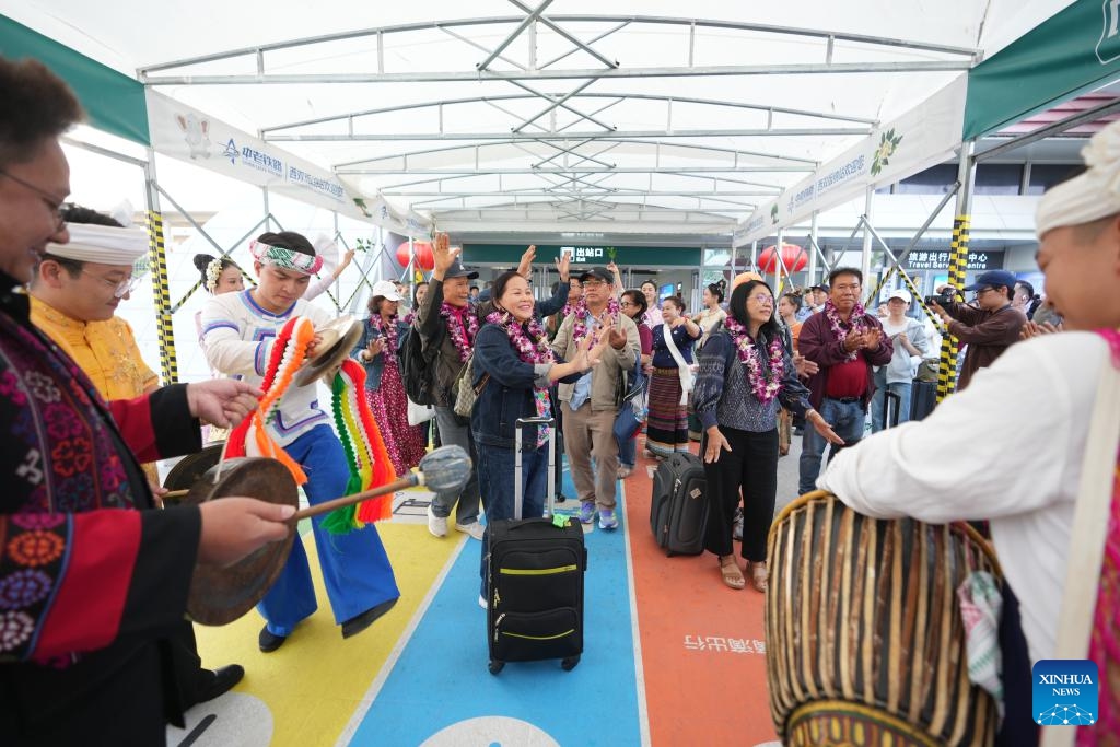 Tourists from Laos and Thailand are greeted upon arrival at the Xishuangbanna railway station in Jinghong City, Xishuangbanna Dai Autonomous Prefecture, southwest China's Yunnan Province, Feb. 18, 2025. After entering through Mohan Port, a tourist group of 15 people from Laos and Thailand took a train and arrived in Jinghong City, Xishuangbanna Dai Autonomous Prefecture on Tuesday. It was the first tourist group to arrive since the implementation of the visa-free policy allowing tourist groups from ASEAN (the Association of Southeast Asian Nations) countries to enter Xishuangbanna. (Photo: Xinhua)