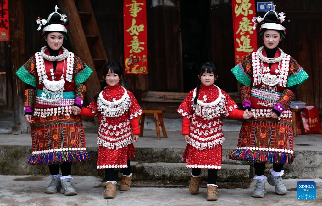 Two pairs of twin sisters pose for a group photo in Zhouxi Village, Zhouxi Town of Kaili, Qiandongnan Miao and Dong Autonomous Prefecture, southwest China's Guizhou Province, Feb. 15, 2025. Donning in traditional attire, accompanied by the melody of Lusheng, a traditional musical instrument, local people in Kaili rejoiced the annual Gannangxiang festival in Zhouxi Town of Kaili. (Photo: Xinhua)