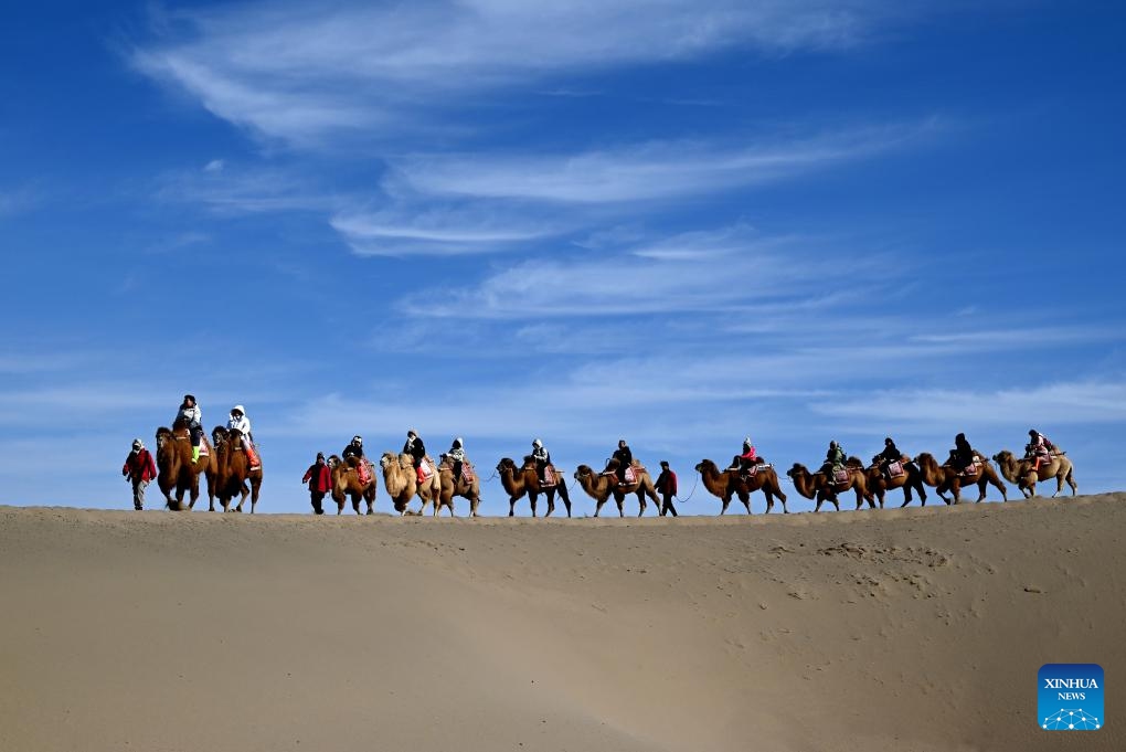 Visitors ride camels at the mingsha mountain and crescent spring scenic spot in Dunhuang, northwest China's Gansu Province, Feb. 4, 2025. Around 2,000 years ago, Dunhuang was a key hub on the ancient Silk Road. Chinese silk and tea passed through this gateway en route to other countries, while agricultural products such as grapes, carrots and pomegranates made their way into China. (Photo: Xinhua)