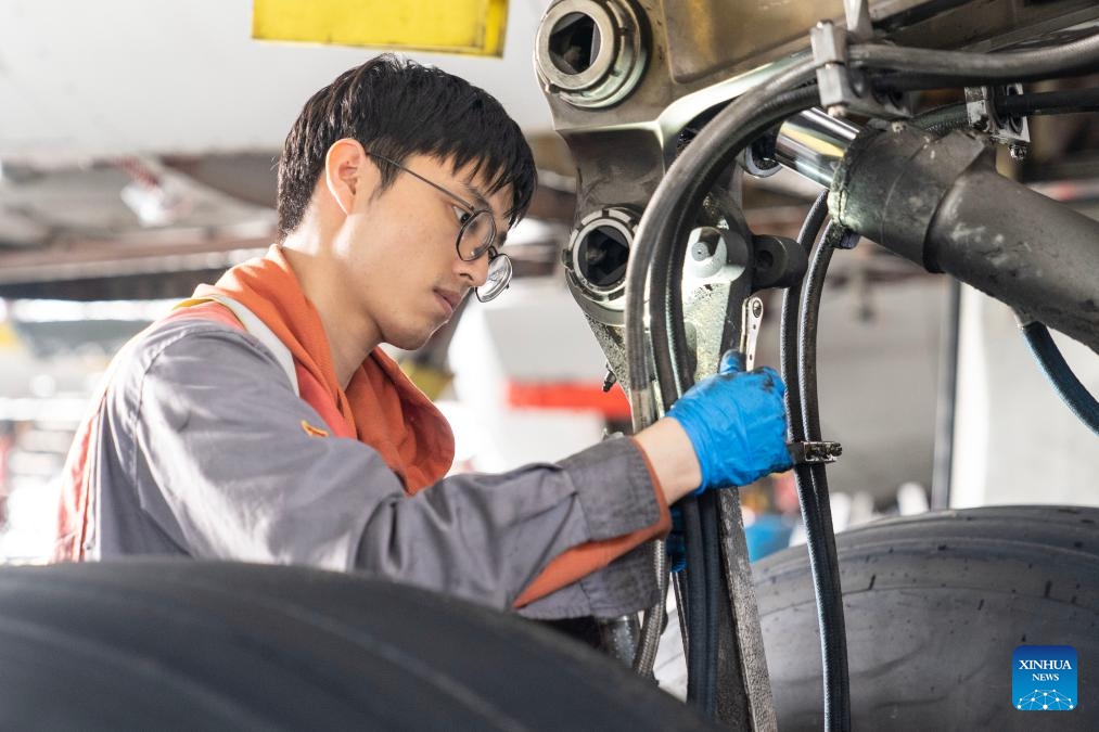 A staff member works on an inbound airplane at a one-stop aircraft maintenance base of Hainan Free Trade Port in Haikou, south China's Hainan Province, Feb. 17, 2025. Since the one-stop aircraft maintenance base of Hainan Free Trade Port was put into use in 2022, a total of 83 aircraft and 17 engines have been maintained and repaired in the bonded zone, with a total value of 45.05 billion yuan (about 6.2 billion U.S. dollars). (Photo: Xinhua)