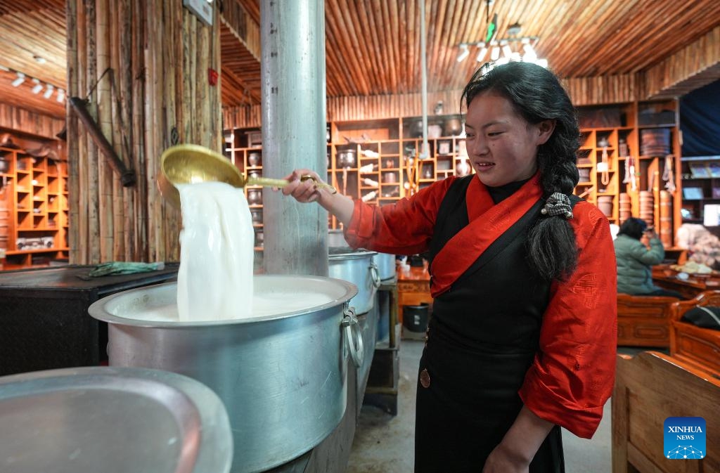 A server makes milk tea at a Tibetan-style teahouse in Seni District of Nagqu, southwest China's Xizang Autonomous Region, Feb. 13, 2025. Covering an area of around 1,200 square meters, the Tibetan-style teahouse presents customers with both Tibetan delicacies and immersive experiences of folklore culture. Themed over 3,000 pieces of traditional Tibetan folk artifacts, the teahouse offers a lens through which people can learn about the northern Xizang nomadic culture. (Photo: Xinhua)