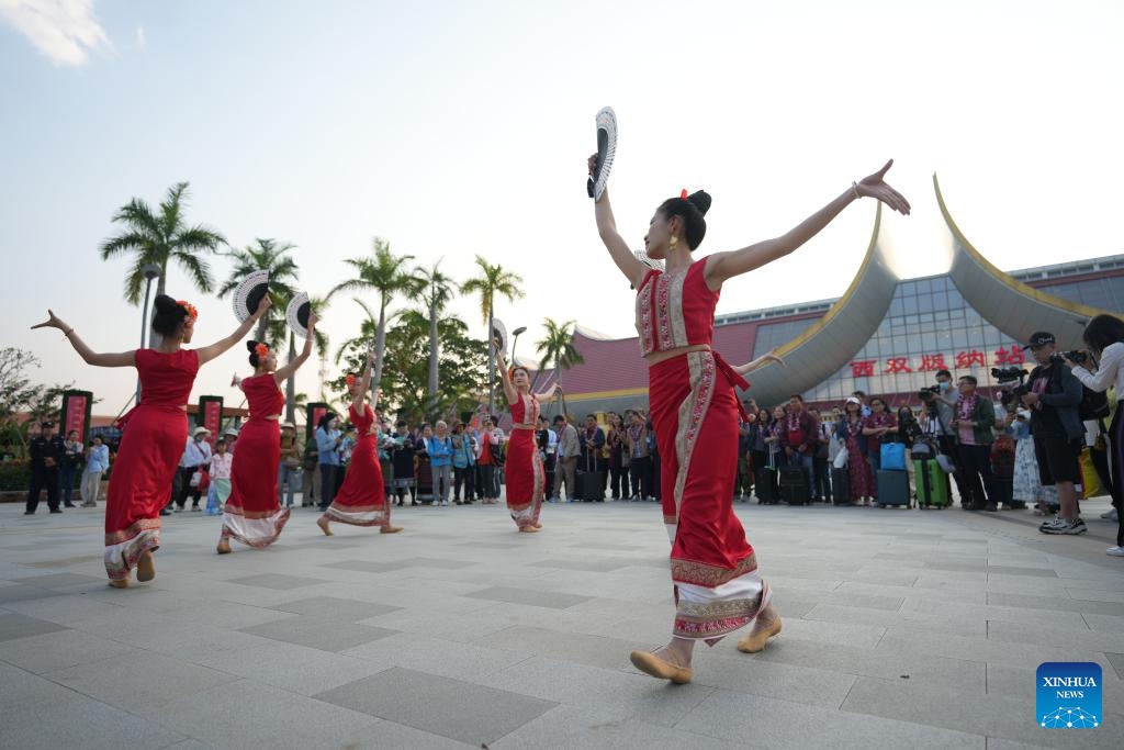 Actresses perform for tourists from Laos and Thailand in front of the Xishuangbanna railway station in Jinghong City, Xishuangbanna Dai Autonomous Prefecture, southwest China's Yunnan Province, Feb. 18, 2025. After entering through Mohan Port, a tourist group of 15 people from Laos and Thailand took a train and arrived in Jinghong City, Xishuangbanna Dai Autonomous Prefecture on Tuesday. It was the first tourist group to arrive since the implementation of the visa-free policy allowing tourist groups from ASEAN (the Association of Southeast Asian Nations) countries to enter Xishuangbanna. (Photo: Xinhua)