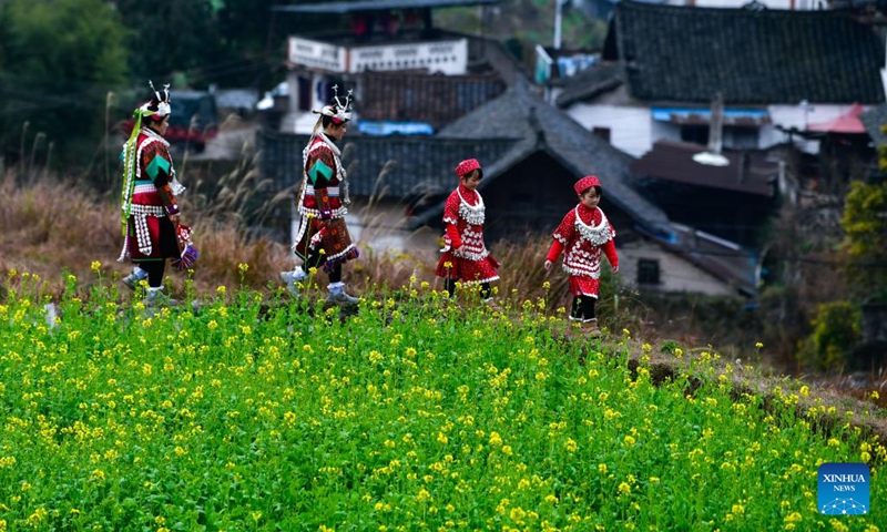 Two pairs of twin sisters are on their way to participate in the celebration of Gannangxiang festival in Zhouxi Village, Zhouxi Town of Kaili, Qiandongnan Miao and Dong Autonomous Prefecture, southwest China's Guizhou Province, Feb. 15, 2025. Donning in traditional attire, accompanied by the melody of Lusheng, a traditional musical instrument, local people in Kaili rejoiced the annual Gannangxiang festival in Zhouxi Town of Kaili. (Photo: Xinhua)