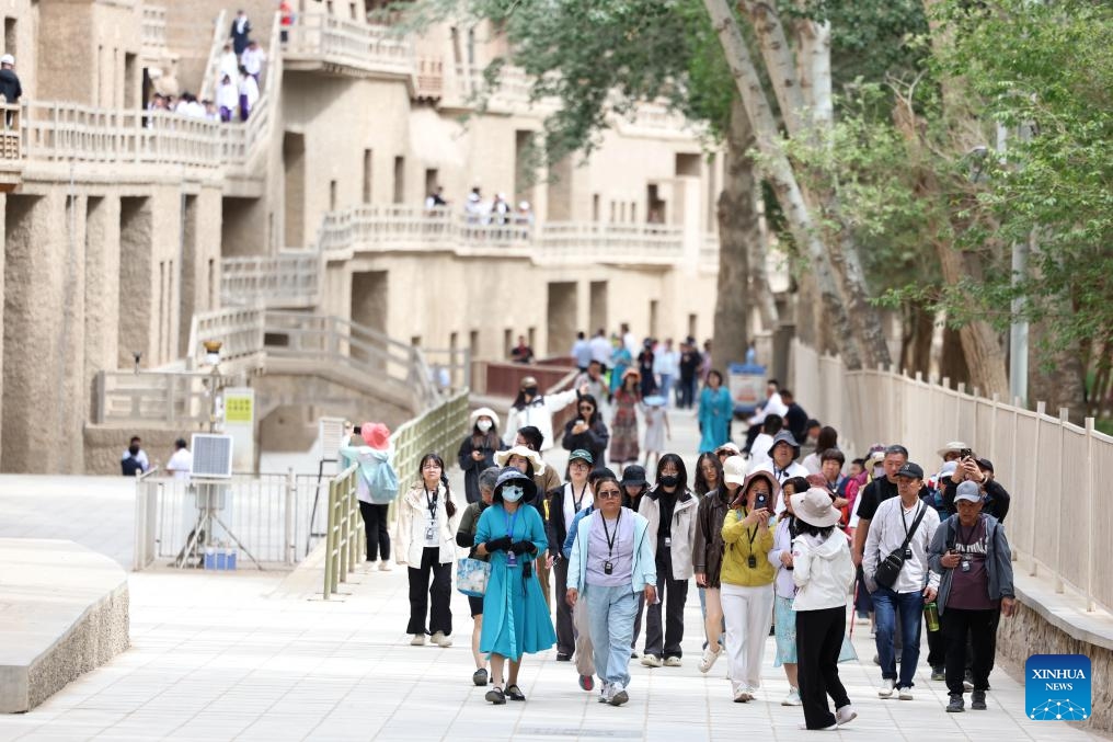 Tourists visit the Mogao Caves in Dunhuang, northwest China's Gansu Province, June 7, 2024. Around 2,000 years ago, Dunhuang was a key hub on the ancient Silk Road. Chinese silk and tea passed through this gateway en route to other countries, while agricultural products such as grapes, carrots and pomegranates made their way into China. (Photo: Xinhua)