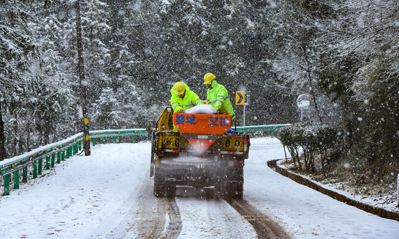 An emergency rescue team spreads road salt to melt the snow on the ground at the Shuanglong Scenic Tourist Area in Jinhua, East China's Zhejiang Province, on February 20, 2025. Snow or sleet will fall in the next few days in southern China and other places, according to weather forecast. Photo: VCG
