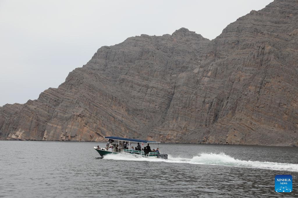 Tourists take a boat to enjoy the scenery of the Musandam Fjords in Oman on Feb. 18, 2025. With steep cliffs, winding bays, and crystal-clear waters, the Musandam Fjords, located at the northernmost tip of Oman, is one of the most beautiful coastlines in the Middle East. (Photo: Xinhua)